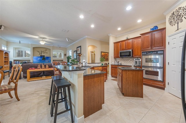 1686 Shadowmoss Cir, Lake Mary, FL 32746 - kitchen featuring stainless steel appliances, an island with sink, ornamental molding, decorative backsplash, and open floor plan