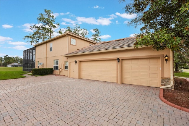 1686 Shadowmoss Cir, Lake Mary, FL 32746 - view of side of home with decorative driveway, stucco siding, a garage, and a tiled roof
