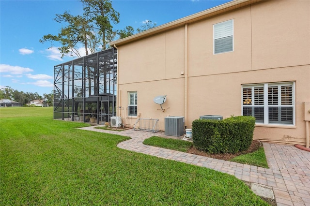 1686 Shadowmoss Cir, Lake Mary, FL 32746 - back of house featuring cooling unit, a yard, glass enclosure, and stucco siding