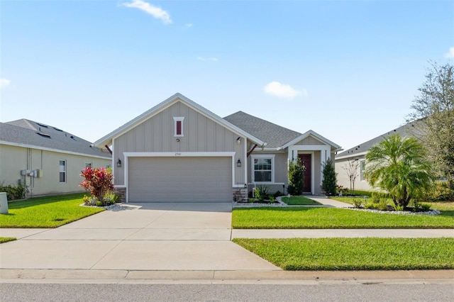 craftsman inspired home featuring an attached garage, concrete driveway, roof with shingles, board and batten siding, and a front yard