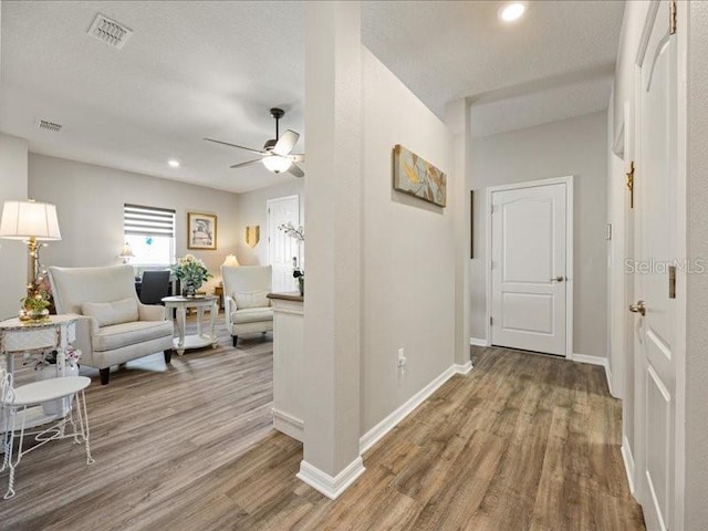 corridor with recessed lighting, wood finished floors, visible vents, and baseboards