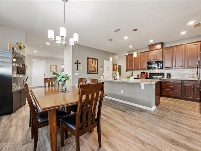 dining room featuring a notable chandelier, recessed lighting, visible vents, light wood-style floors, and baseboards