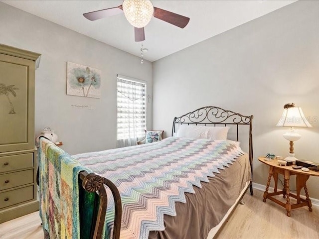 bedroom featuring light wood-style flooring, baseboards, and ceiling fan