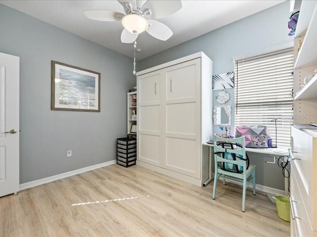 office space featuring ceiling fan, light wood-style flooring, and baseboards