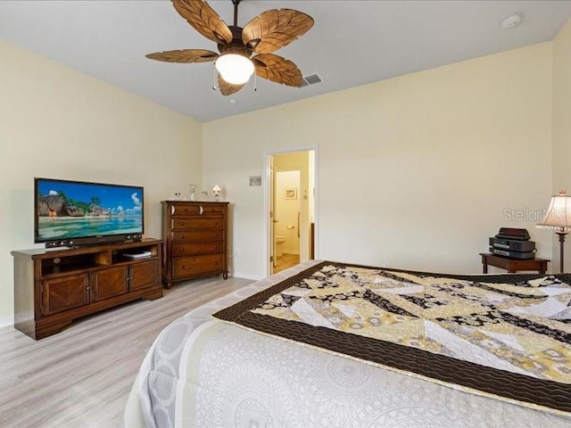 bedroom featuring ensuite bath, wood finished floors, visible vents, and a ceiling fan