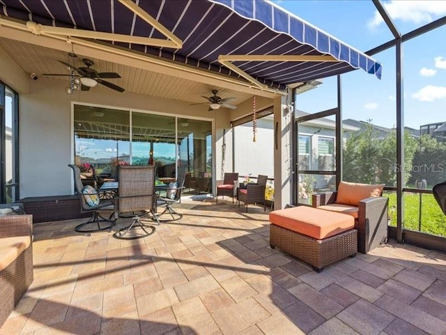 view of patio / terrace with a ceiling fan, outdoor dining space, glass enclosure, and an outdoor living space