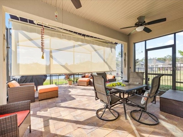 sunroom / solarium featuring a ceiling fan