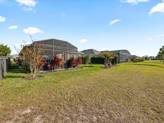 view of yard featuring glass enclosure and fence