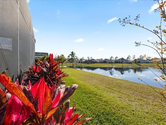 view of yard with a lanai and a water view