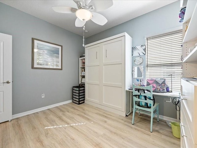 home office featuring light wood-style flooring, baseboards, and a ceiling fan