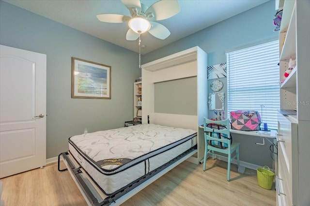 bedroom featuring a ceiling fan, baseboards, and light wood-style floors