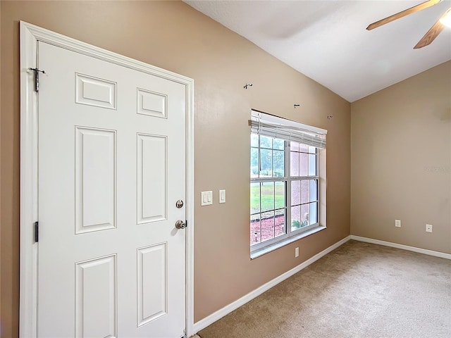 carpeted foyer entrance with lofted ceiling, baseboards, and a ceiling fan