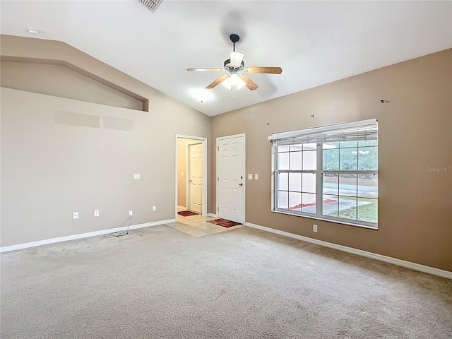 unfurnished room featuring lofted ceiling, ceiling fan, light colored carpet, visible vents, and baseboards