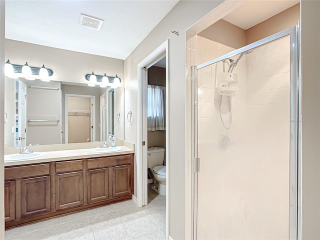 full bathroom featuring toilet, a sink, visible vents, and a shower stall