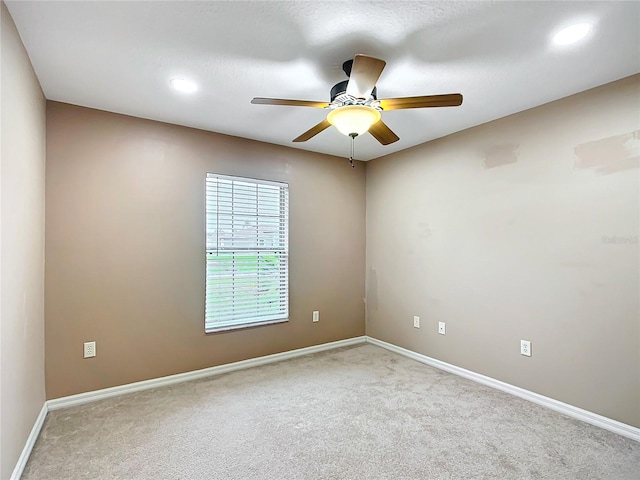 empty room featuring carpet floors, a ceiling fan, and baseboards