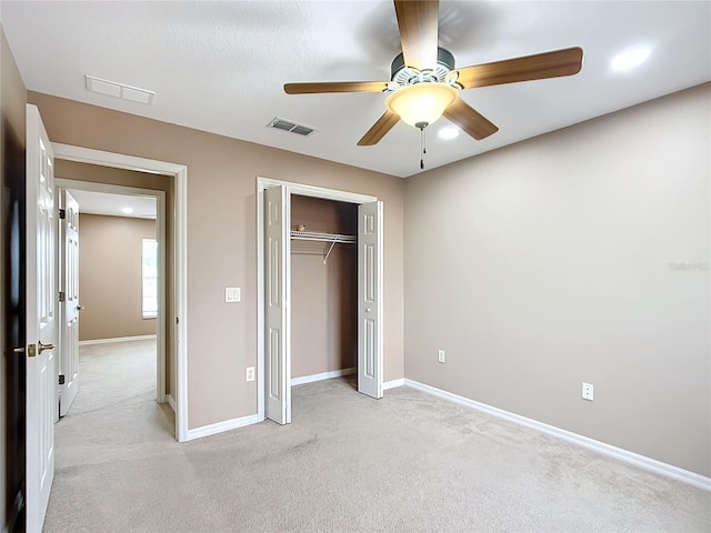 unfurnished bedroom with light colored carpet, a closet, visible vents, and baseboards