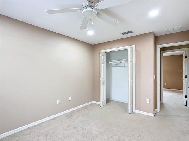 unfurnished bedroom featuring a closet, visible vents, light carpet, and baseboards