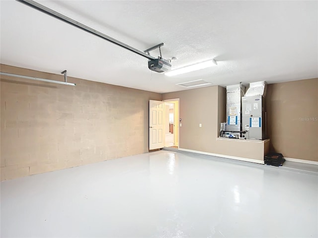 garage with a garage door opener, concrete block wall, and heating unit