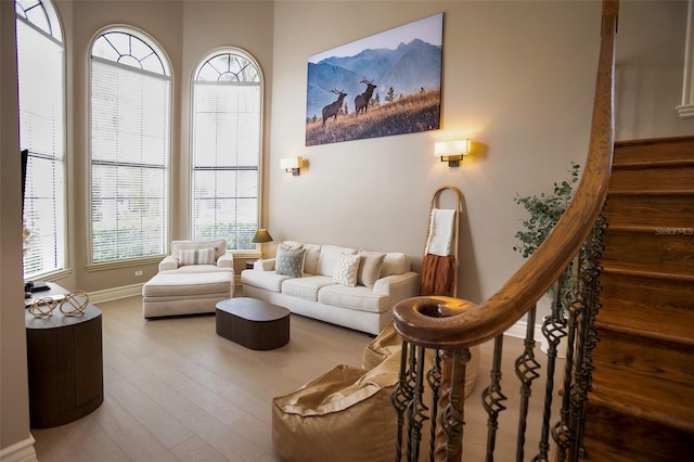 living area with stairway, baseboards, and wood finished floors