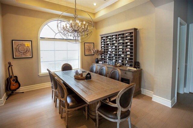 dining space featuring a tray ceiling, baseboards, and wood finished floors