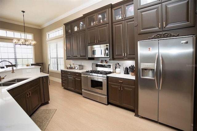 kitchen featuring crown molding, dark brown cabinetry, light countertops, appliances with stainless steel finishes, and a sink