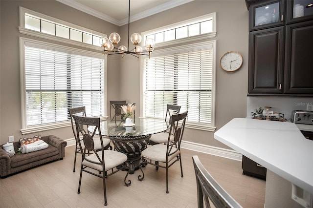 dining space featuring baseboards, a notable chandelier, light wood-style flooring, and crown molding