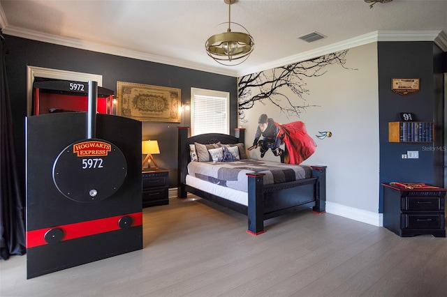 bedroom with crown molding, wood finished floors, visible vents, and baseboards