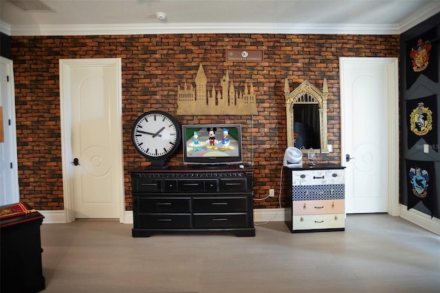 living room featuring brick wall, crown molding, and baseboards