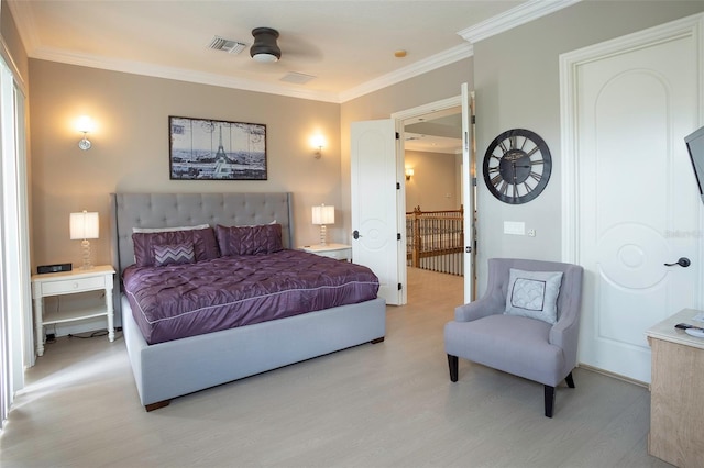 bedroom featuring light wood-type flooring, visible vents, and crown molding