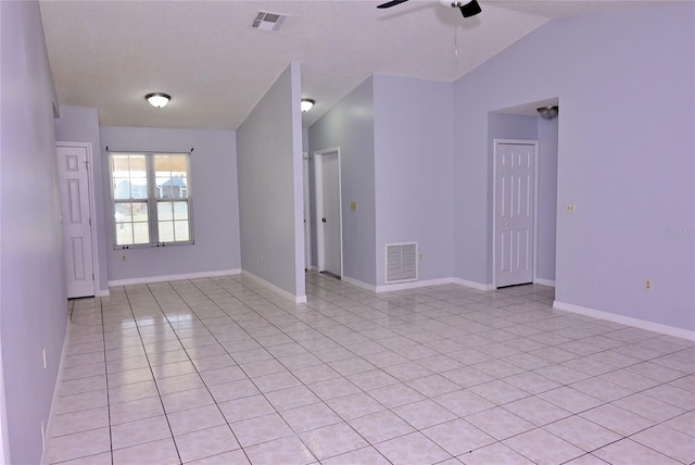 spare room with lofted ceiling, baseboards, visible vents, and a ceiling fan