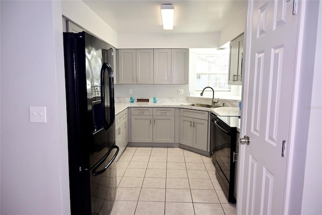 kitchen with dishwashing machine, light tile patterned flooring, a sink, gray cabinets, and black refrigerator with ice dispenser