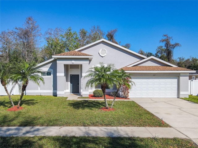 view of front facade featuring a front yard, concrete driveway, an attached garage, and stucco siding