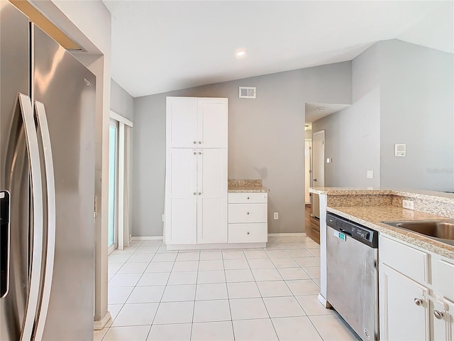 kitchen featuring stainless steel appliances, lofted ceiling, visible vents, and light tile patterned floors