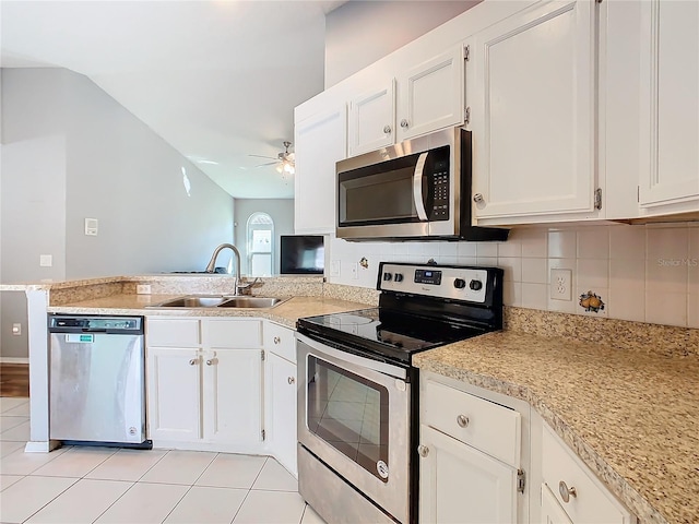 kitchen with appliances with stainless steel finishes, light countertops, a sink, and a peninsula