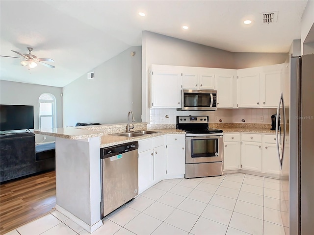 kitchen featuring visible vents, appliances with stainless steel finishes, open floor plan, white cabinetry, and a sink