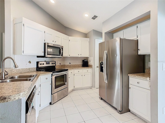 kitchen featuring visible vents, white cabinets, stainless steel appliances, light countertops, and a sink