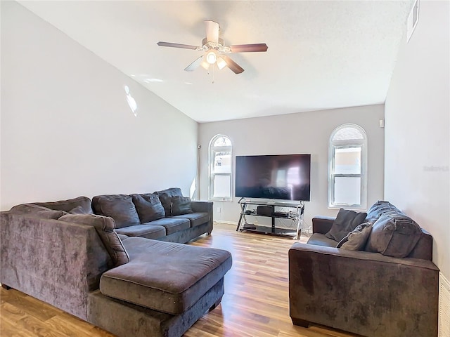 living area with a wealth of natural light, visible vents, and wood finished floors