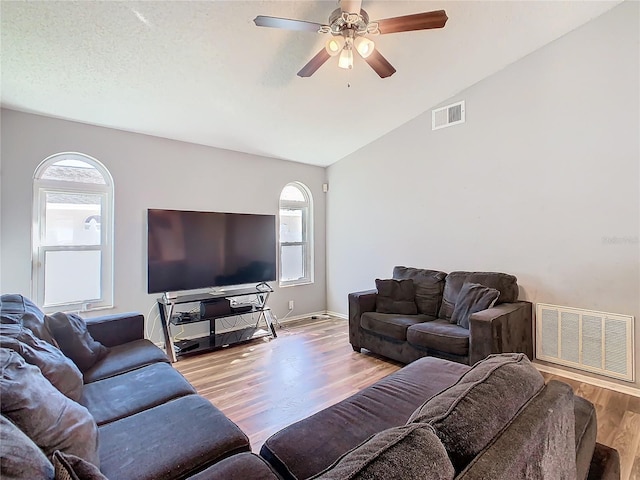 living room with lofted ceiling, a healthy amount of sunlight, and visible vents