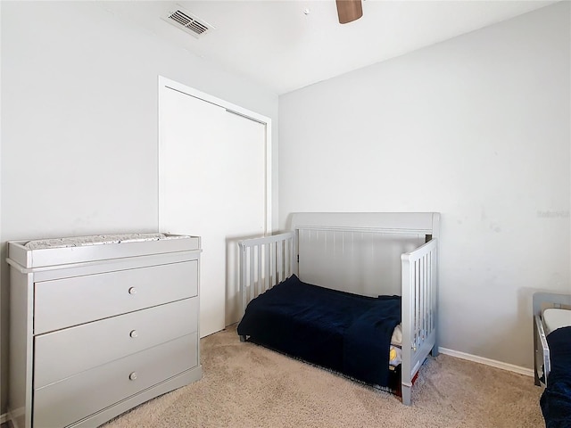 bedroom with light colored carpet, visible vents, and ceiling fan