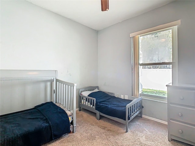 bedroom with ceiling fan, baseboards, and carpet flooring