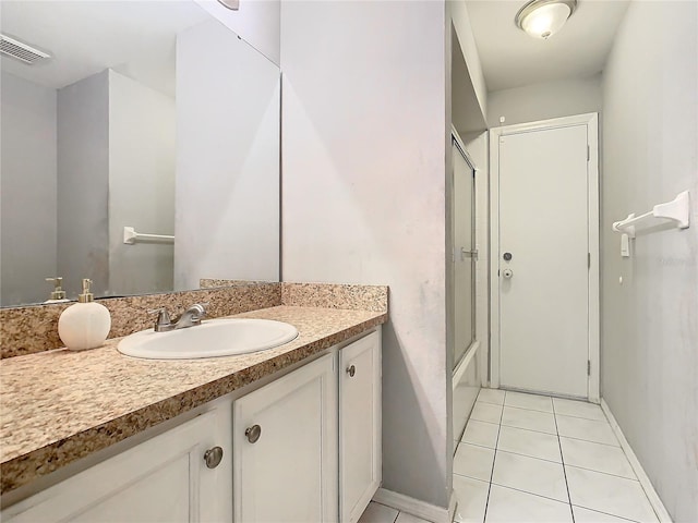 full bathroom with enclosed tub / shower combo, vanity, baseboards, visible vents, and tile patterned floors