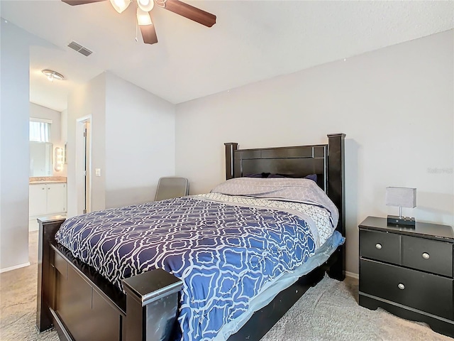 carpeted bedroom featuring lofted ceiling, visible vents, ensuite bathroom, ceiling fan, and baseboards