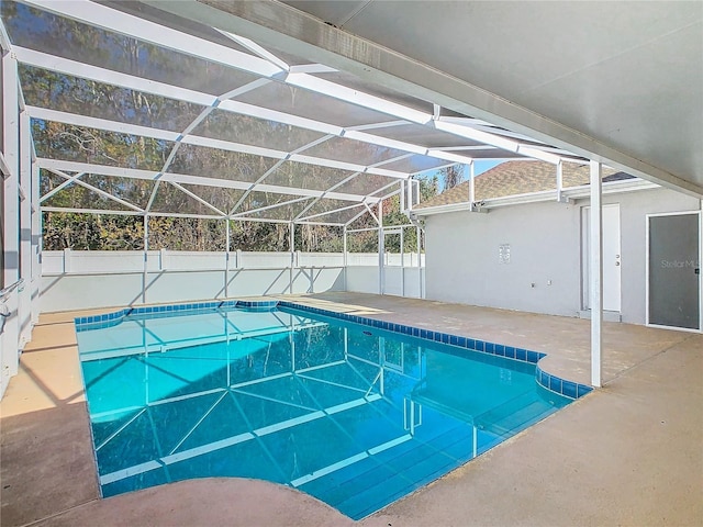 view of pool featuring glass enclosure, fence, a fenced in pool, and a patio