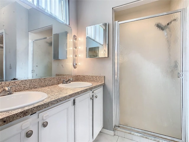 full bath with tile patterned floors, a sink, a shower stall, and double vanity