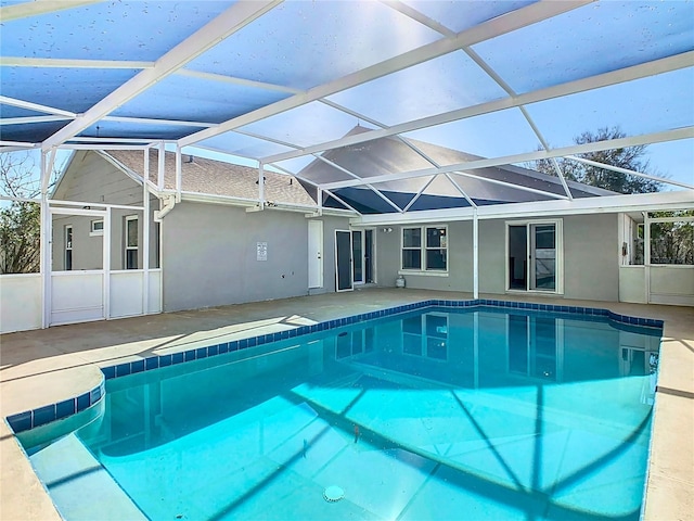 pool with a patio and glass enclosure