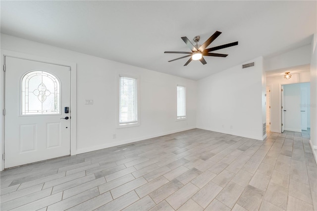 foyer featuring a ceiling fan, visible vents, vaulted ceiling, and baseboards