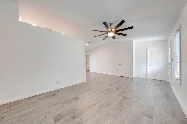 empty room featuring lofted ceiling, visible vents, a ceiling fan, light wood-style floors, and baseboards