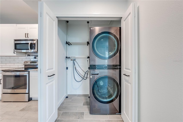 washroom with stacked washer and dryer and laundry area