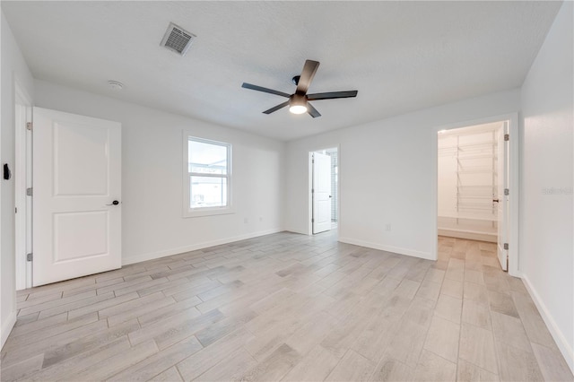 spare room with light wood-style flooring, visible vents, and baseboards