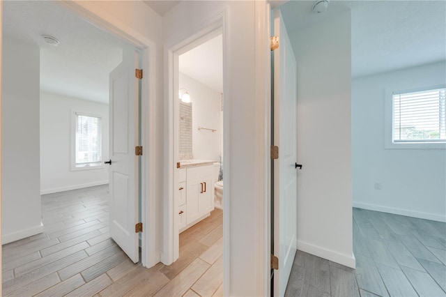 hall featuring wood tiled floor and baseboards